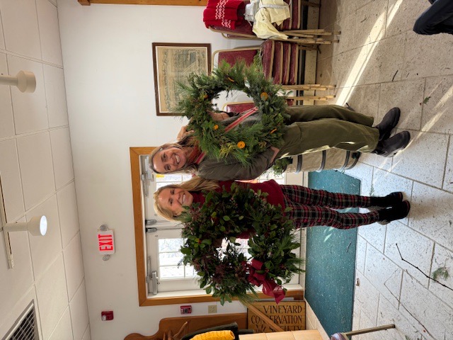 Women holding Christmas wreaths